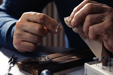 Wall Mural - Professional jeweler working with ring at table, closeup