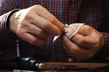 Wall Mural - Professional jeweler working with ring at table, closeup