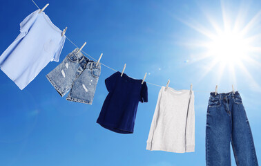 Wall Mural - Different clothes drying on washing line against blue sky