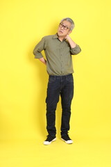 Poster - The 40s adult Asian man with casual dressed standing on the yellow background.