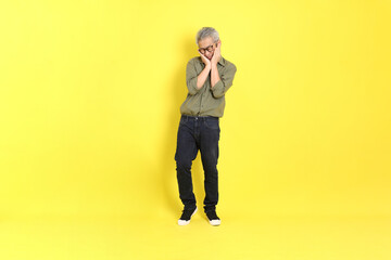 Poster - The 40s adult Asian man with casual dressed standing on the yellow background.