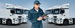 © scharfsinn86 - Manager with a digital tablet next to trucks. Fleet management