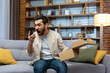 © Liubomir - Angry cheated man at home with phone and boxed parcel received, arguing on phone talking to online store customer support service, product delivery failed.