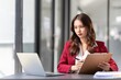 © Natee Meepian - Young Asian businesswoman sitting at their desk and take notes using laptop in the office