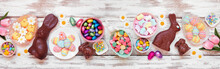 Easter Candy Table Scene. Above View Over A White Wood Banner Background. Chocolate Bunnies, Candy Eggs And Assorted Sweets.