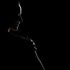 Wall Mural - Sensual portrait silhouette of beautiful smiling woman in backlight on a black background