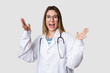 © Asier - Compassionate female physician with a stethoscope around her neck, ready to diagnose and care for her patients in her signature white coat receiving a pleasant surprise, excited and raising hands.