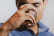 © JAHF - hombre joven triste y mirando con bebida en su mano en un fondo gris y espacio para texto, concepto de problemas con las bebidas alcohólicas, depresión, alcoholismo.