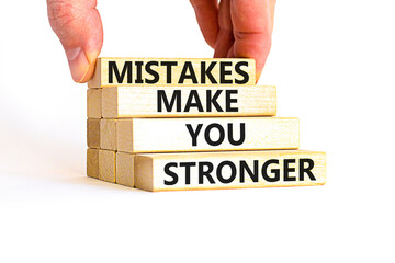 Wall Mural - Mistake make stronger symbol. Concept words Mistakes make you stronger on wooden blocks. Beautiful white background. Businessman hand. Business mistake make stronger concept. Copy space.