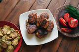 Fototapeta Tulipany - meat with vegetables, rural Ukrainian lunch with fried squash, roasted meatballs and fresh tomatoes with dill
