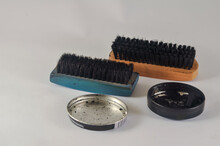 Two Brushes And A Can Of Shoe Polish Isolated On A White Background
