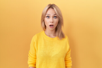 Canvas Print - Young caucasian woman wearing yellow sweater afraid and shocked with surprise and amazed expression, fear and excited face.