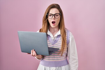 Poster - Young caucasian woman working using computer laptop angry and mad screaming frustrated and furious, shouting with anger. rage and aggressive concept.