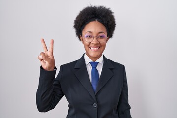 Sticker - Beautiful african woman with curly hair wearing business jacket and glasses showing and pointing up with fingers number two while smiling confident and happy.