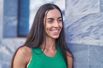 Wall Mural - Young beautiful hispanic woman smiling confident looking to the side at street