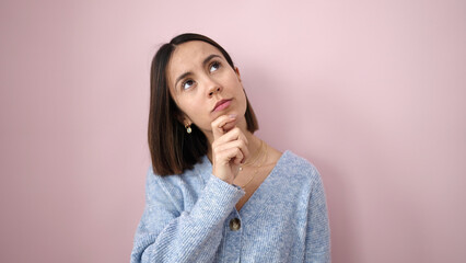 Canvas Print - Young beautiful hispanic woman standing with doubt expression over isolated pink background