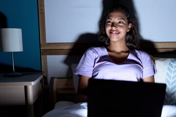 Poster - Young african american woman using laptop sitting on bed at bedroom