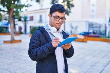 Wall Mural - Down syndrome man wearing headphones using touchpad at park