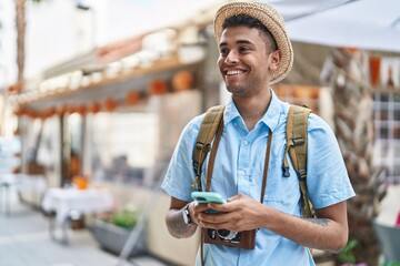 Wall Mural - African american man tourist smiling confident using smartphone at street