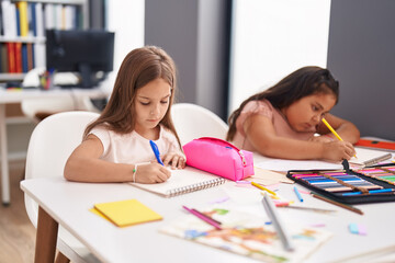 Canvas Print - Two kids preschool students sitting on table drawing on paper at classroom