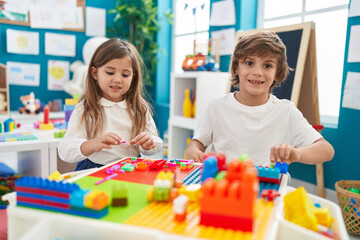 Sticker - Brother and sister playing with construction blocks sitting on table at kindergarten