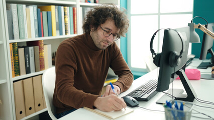 Poster - Young hispanic man student using computer writing on notebook at library university