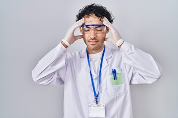 Poster - Hispanic man working at scientist laboratory with hand on head, headache because stress. suffering migraine.