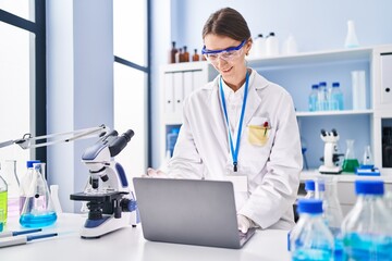 Sticker - Young caucasian woman scientist smiling confident using laptop at laboratory