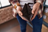 Fototapeta  - Young man showing empty wallet at office