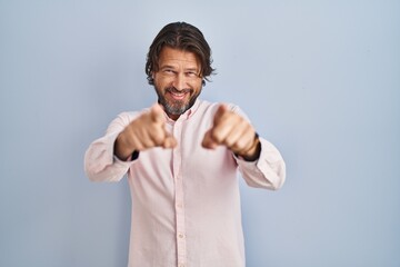 Wall Mural - Handsome middle age man wearing elegant shirt background pointing to you and the camera with fingers, smiling positive and cheerful