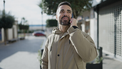 Canvas Print - Young hispanic man smiling confident talking on smartphone at street