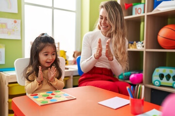 Poster - Teacher and toddler playing with maths puzzle game applauding at kindergarten