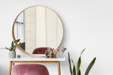 Interior of light makeup room with table, mirror and organizers