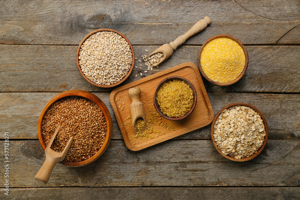 Composition with bowls of different cereals on wooden background