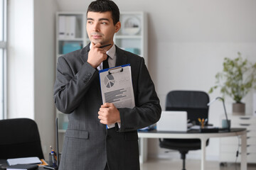 Poster - Thoughtful young accountant with document in office