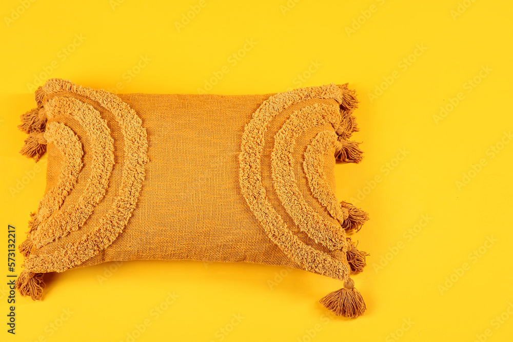 Stylish soft pillow on yellow background