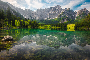 Wall Mural - Green forest and clean alpine lake with high mountains, Italy