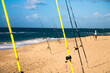 © Cavan Images - A man tends to his fishing rod on the beach.