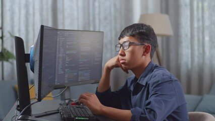 Asian Boy Programmer Being Bored Creating Software Engineer Developing App, Program, Video Game On Desktop Computer At Home. Terminal With Coding Language 
