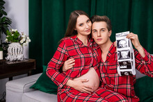 Pregnant Woman Sitting On The Lap Of A Man Holding Usg Photos