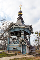 Wall Mural - A view of the wooden bell tower of Trinity Monastery of St. Jonas  on the territory of the Botanical Garden in Kyiv. Ukraine 