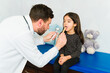 © AntonioDiaz - Doctor checking the sore throat of a child patient
