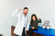 © AntonioDiaz - Cheerful pediatrician smiling with a young girl patient