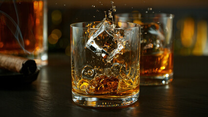 Wall Mural - ice cube fall into a glass with whiskey drink.