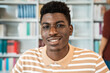 © Alessandro Biascioli - Happy young African man smiling into the camera while standing inside university library