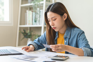 Wall Mural - Financial owe, hand of asian woman sitting, holding credit card, stressed  by calculate expense from invoice or bill, no money to pay, mortgage or loan. Debt, bankruptcy or bankrupt.