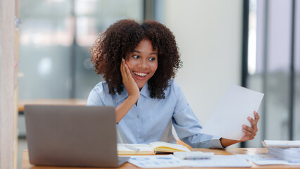 Wall Mural - Businesswoman raising her hand in congratulation with document and laptop computer