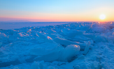 Wall Mural - Beautiful winter landscape of frozen Lake Baikal at sunrise - Snowy ice hummocks with transparent blue piles of ice - Baikal Lake, Siberia