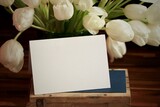 Fototapeta Tulipany - Bukiet tulipanów w tle, a na pierwszym planie biała kartka - zaproszenie z miejscem na tekst. Kwiaty i tekst. Dzień Kobiet.