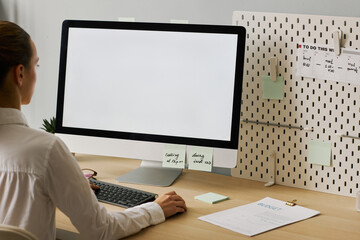 Close up young woman using computer with white screen mockup working at desk